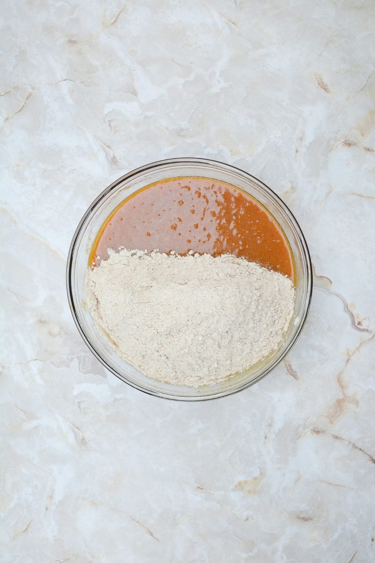 Pumpkin muffin ingredients being mixed together in a large bowl.