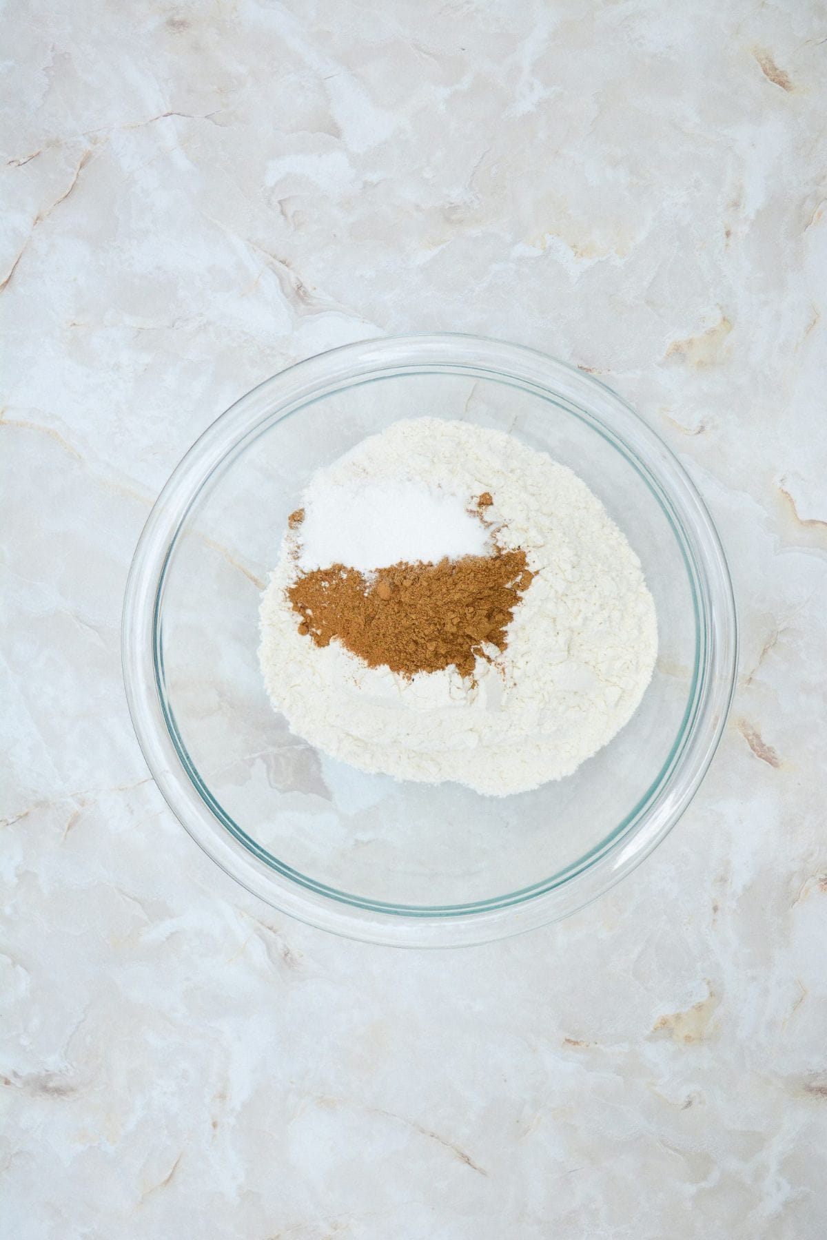 Pumpkin muffin ingredients being mixed together in a large bowl.