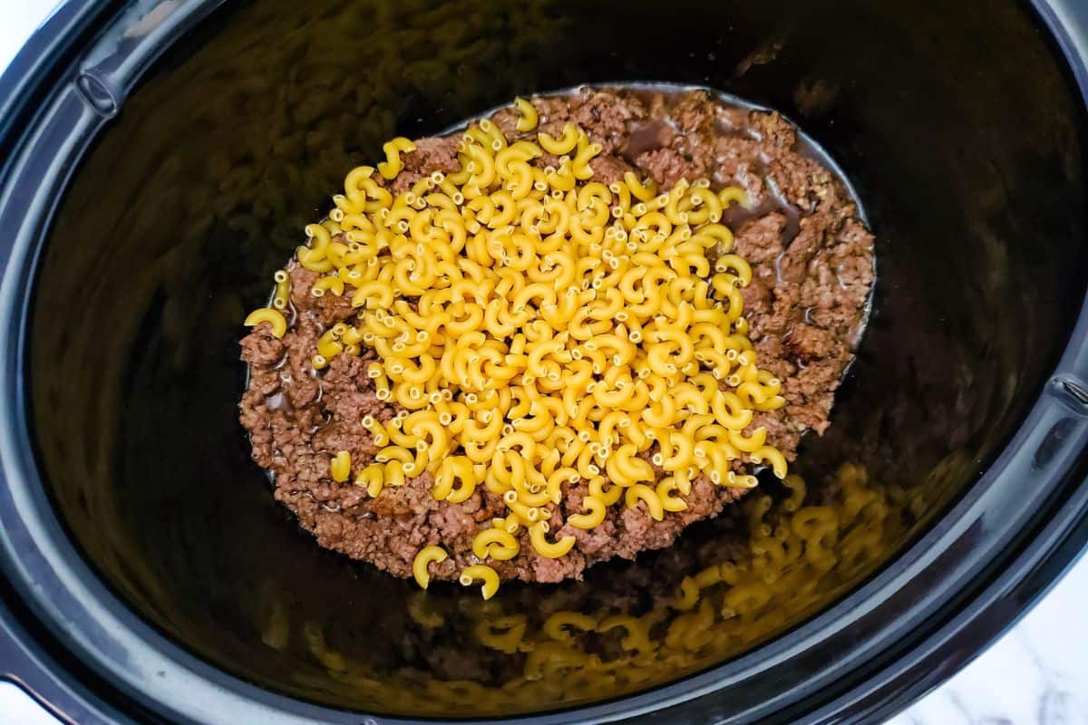 A crockpot filled with cheesy beef and macaroni.