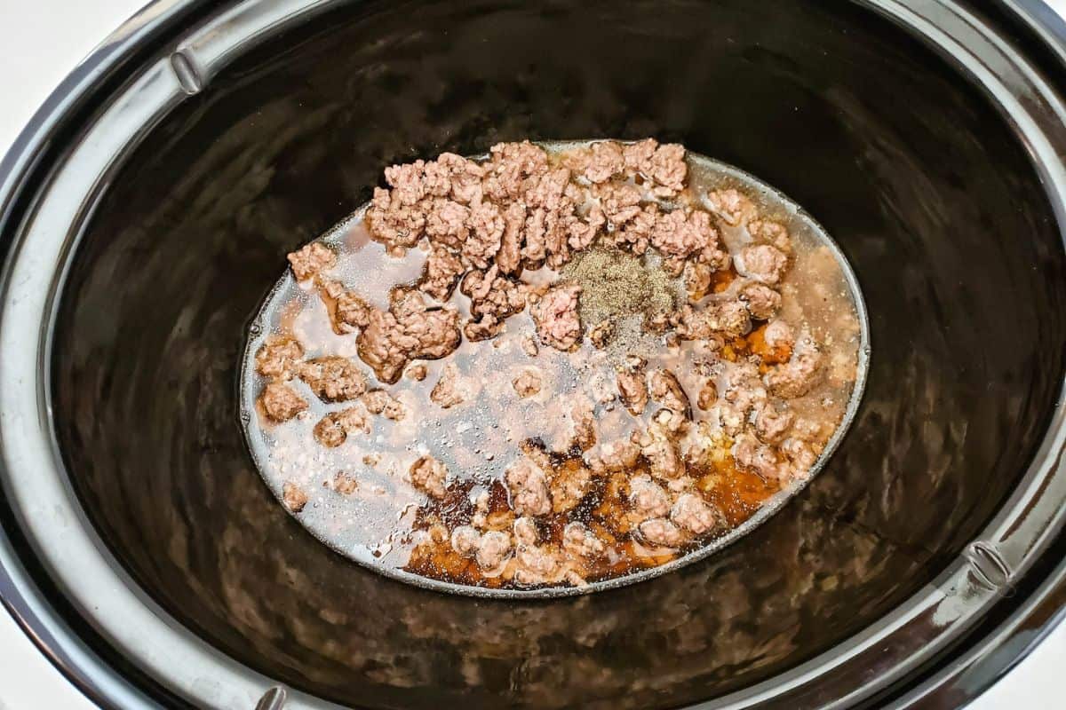 Tender beef chunks soaked in rich broth inside a crockpot.
