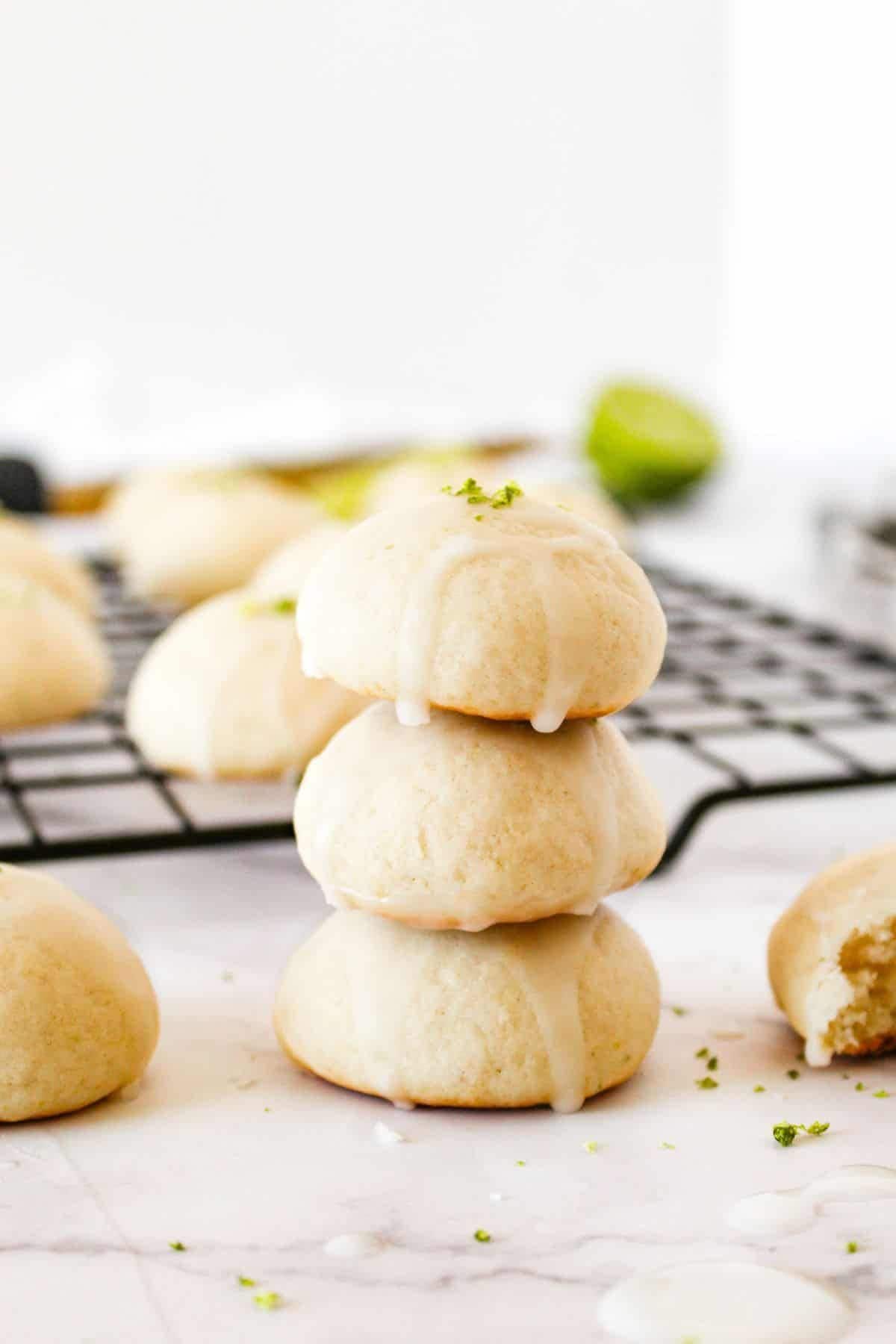 Stack of sourdough discard key lime ricotta cookies on a surface, with more cookies blurred in the background.