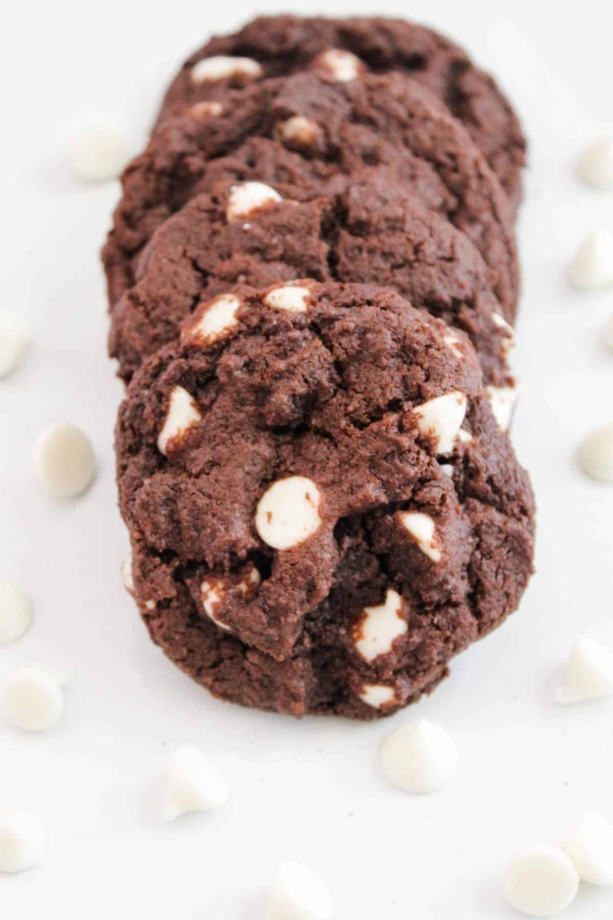 White chocolate chip cookies lined up on a plate, showing melted chocolate chunks and a golden-brown texture.