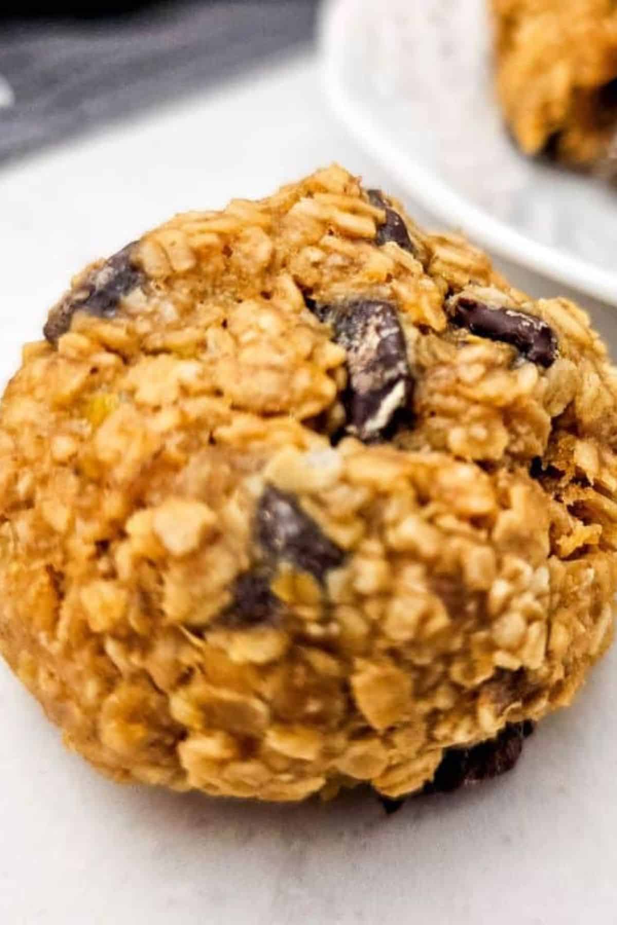 Single banana oatmeal cookie ball on a surface, showing its texture and natural ingredients.