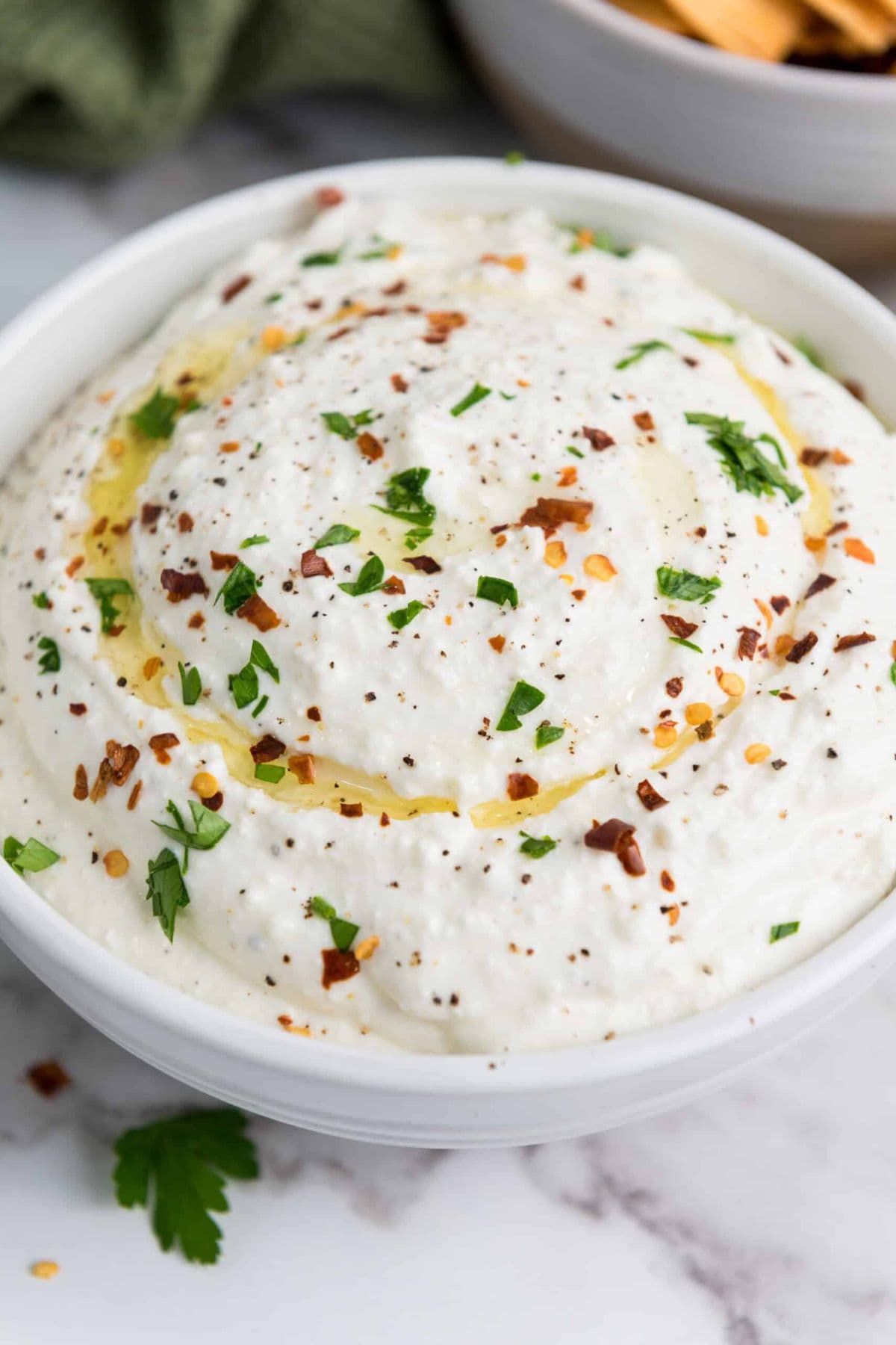 Close-up photo of zesty lemony whipped feta dip served in a bowl.