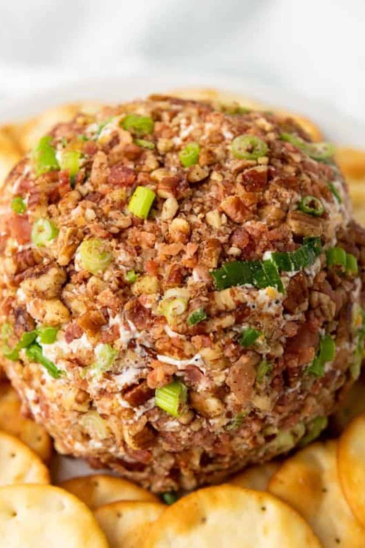 Close-up of a pecan cheeseball showing its creamy interior and crunchy pecan coating.