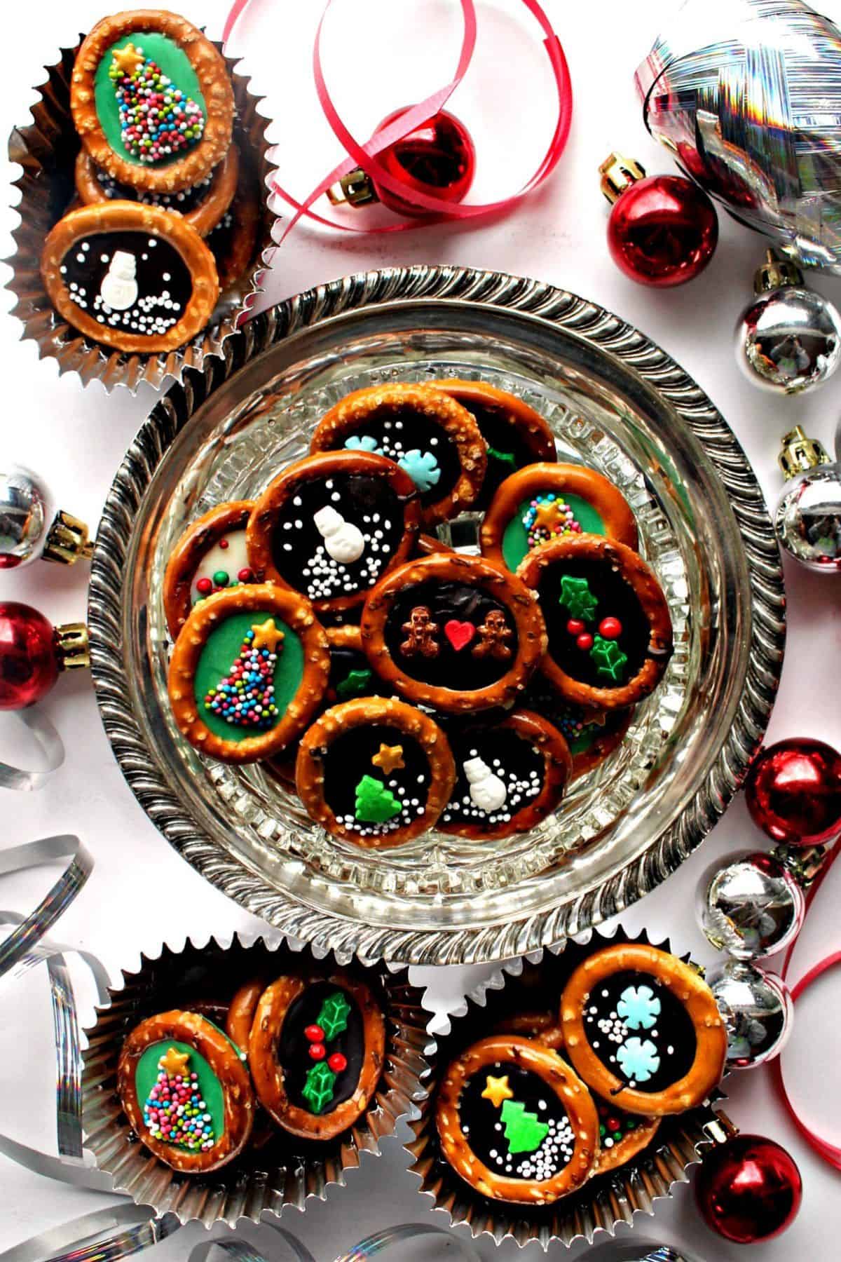 Decorative Christmas Pretzels arranged on a plate, surrounded by festive Christmas decorations.