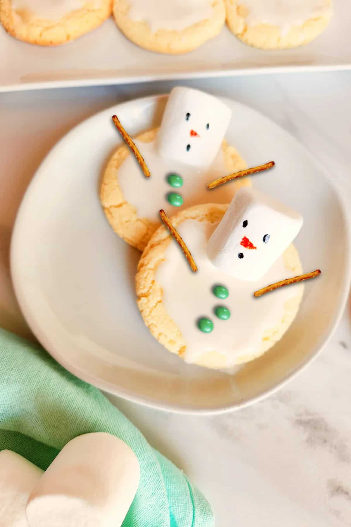Melted Snowman Cookies arranged on a plate, with more cookies blurred in the background.