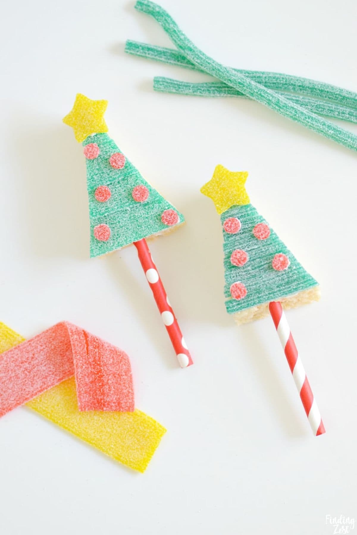 Christmas Tree Rice Krispie Treats on a surface, with gummy jelly sticks placed on the side.