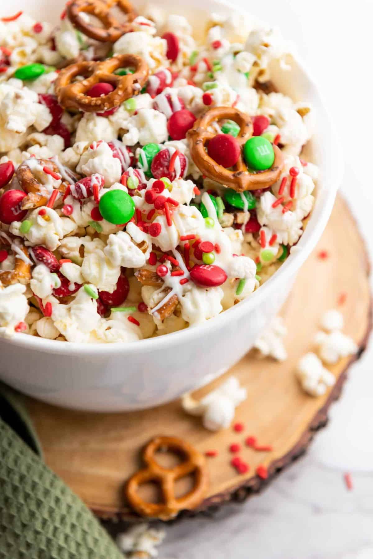 Close-up of Christmas popcorn in a large bowl, coated with colorful candy and sprinkles.