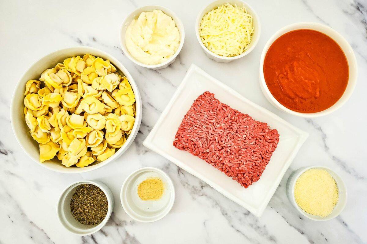 Cheesy Baked Tortellini ingredients arranged on a kitchen counter.
