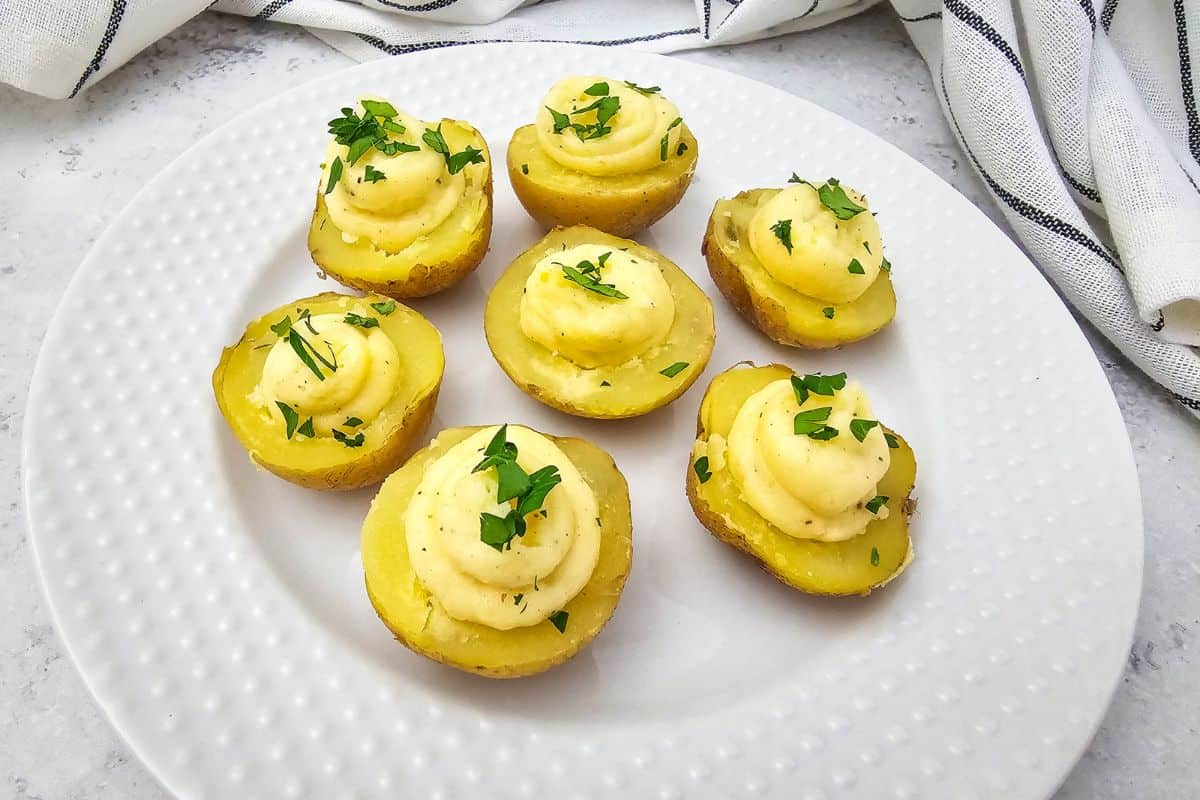 A plate of deviled potatoes topped with fresh parsley.