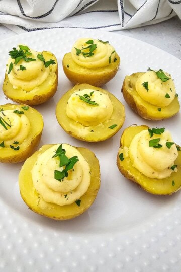 A plate of deviled potatoes topped with fresh parsley.