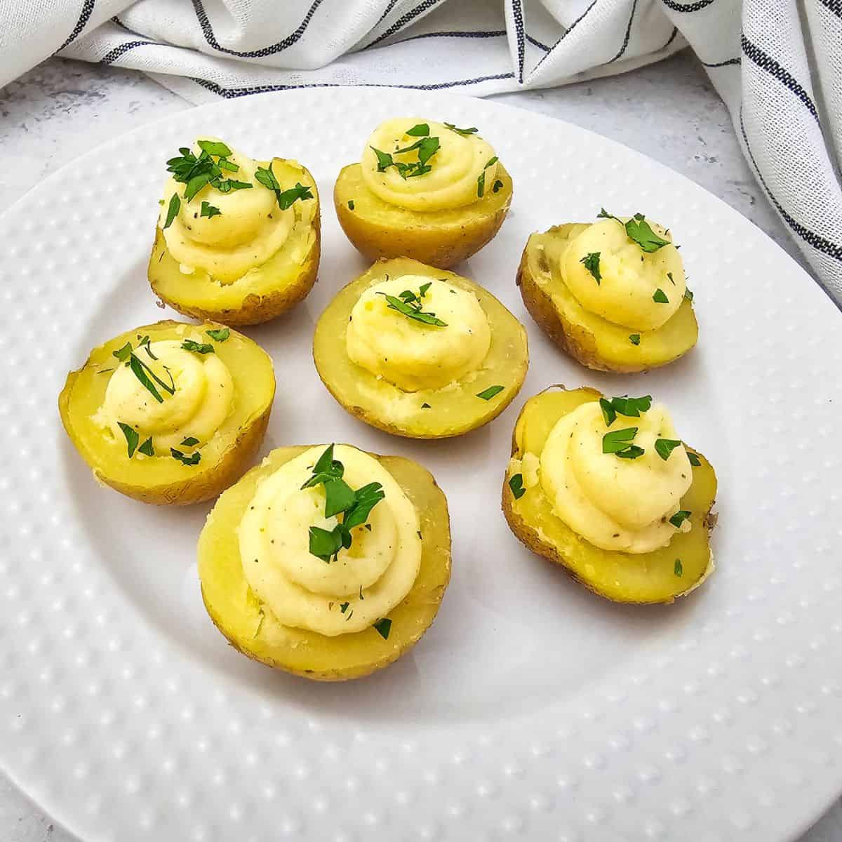 A plate of deviled potatoes topped with fresh parsley.