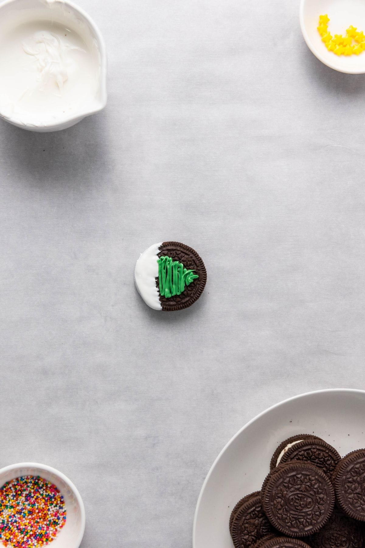 Single Christmas tree Oreo on a surface.