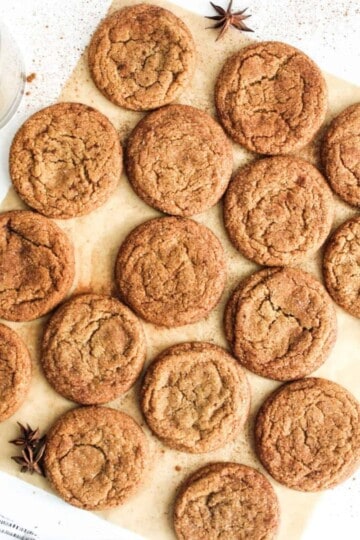 Cookies being flattened and lined up on a wooden board.