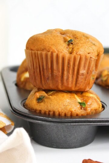 Freshly baked muffins stacked on top of each other in a muffin tin.