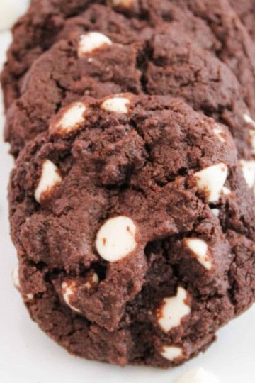 White chocolate cookies on a surface, surrounded by white chocolate kisses.