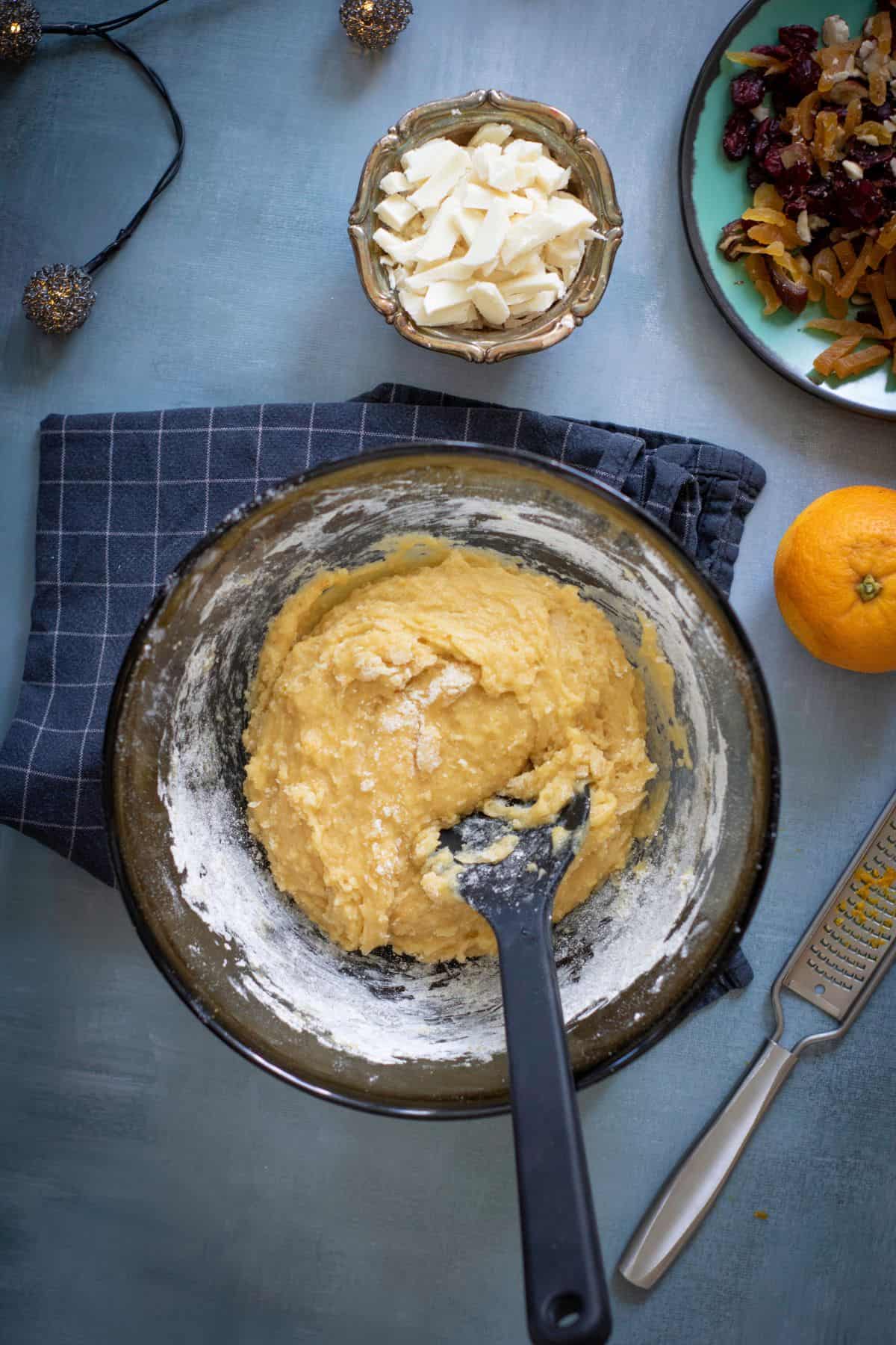 Wet and dry ingredients being mixed in a large bowl with a spatula.