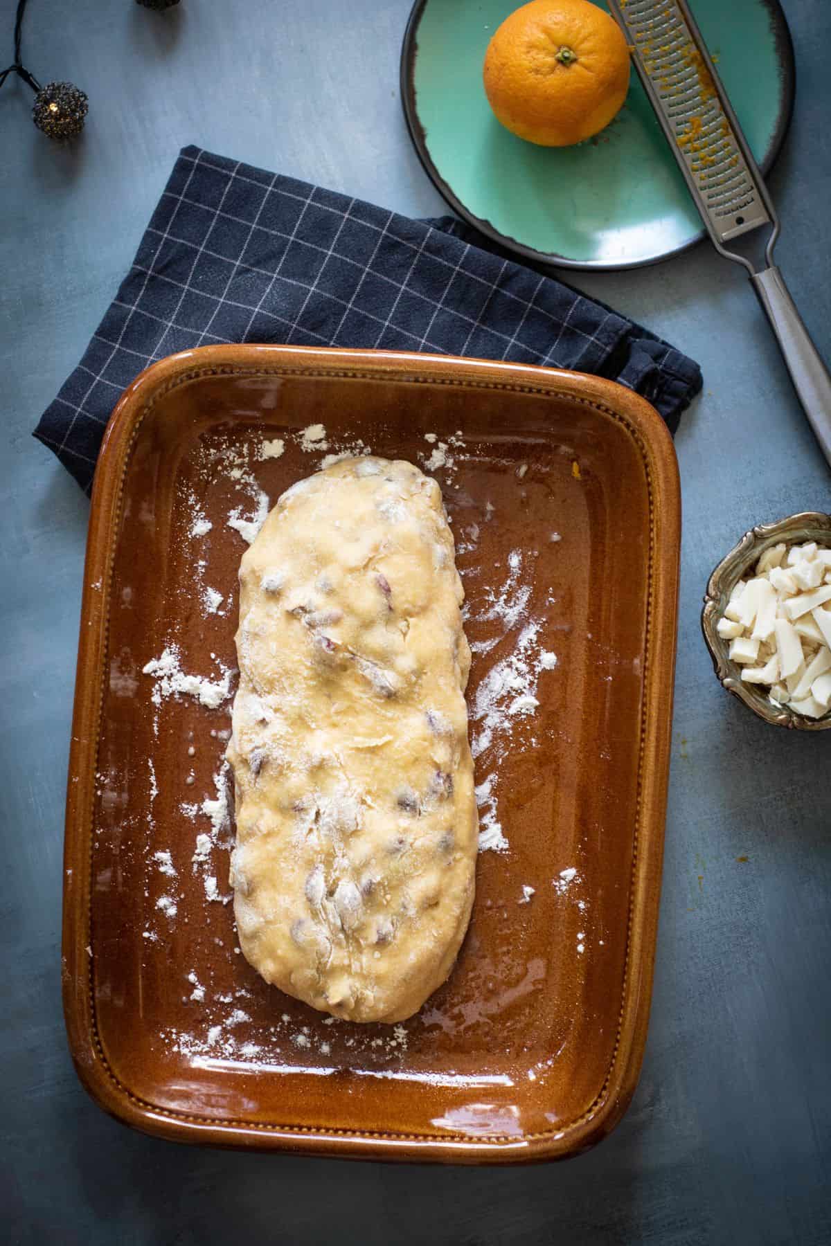 Biscotti dough shaped into a log on a floured baking sheet.