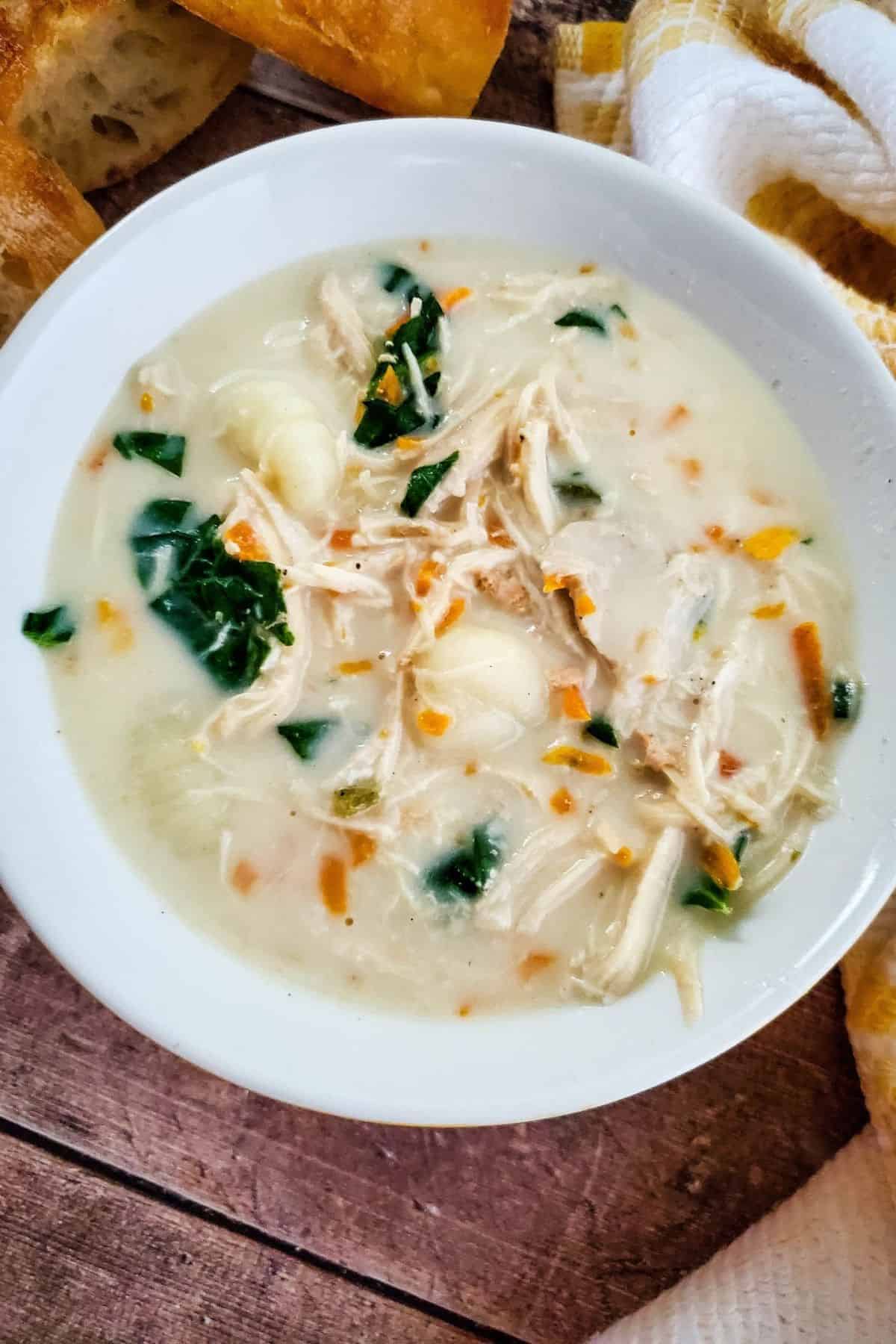 Crockpot chicken gnocchi soup served in a bowl with creamy broth, chicken, gnocchi, and vegetables.