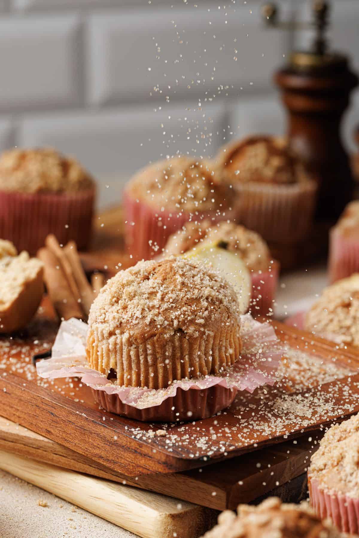 Apple cinnamon muffins served on a wooden board.