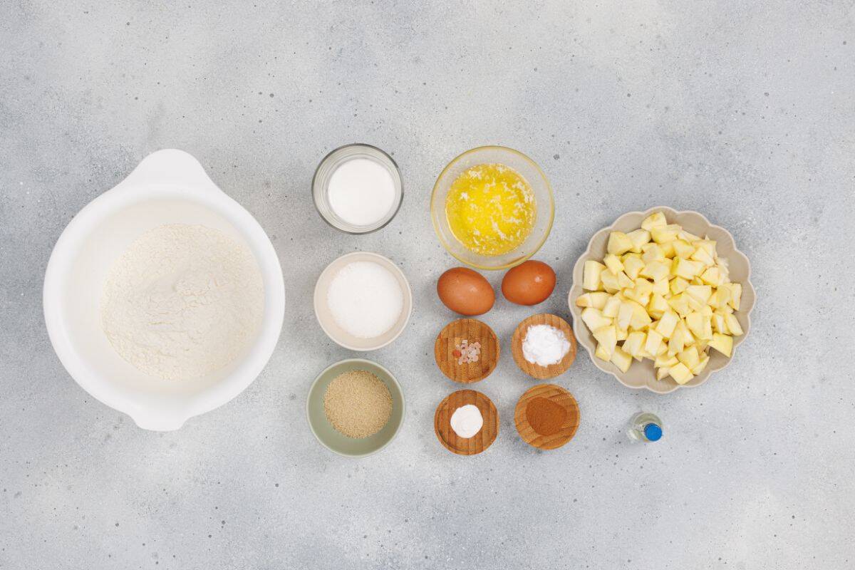 Ingredients for apple cinnamon muffins displayed on a surface.