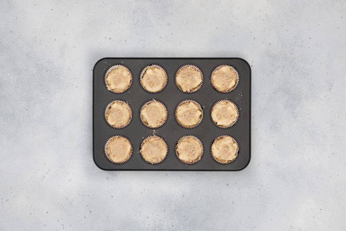 Apple cinnamon muffins placed in a baking tray ready to be baked.
