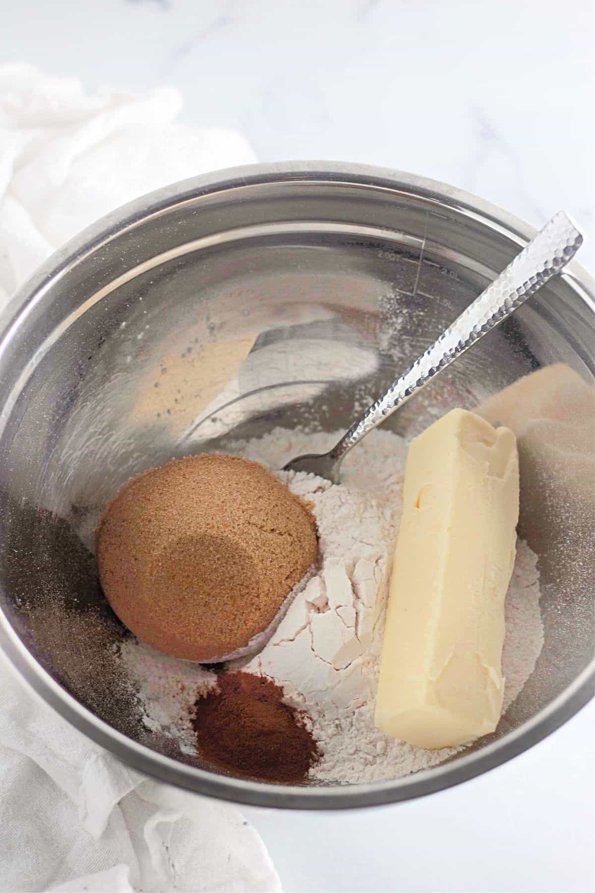 Ingredients for the apple filling being mixed in a large bowl with a fork resting on the side.