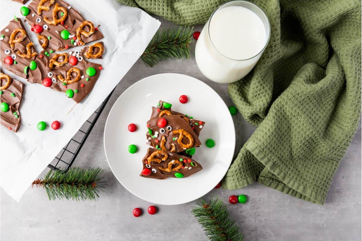 Served chocolate bark on a plate with a glass of milk and cloth underneath.