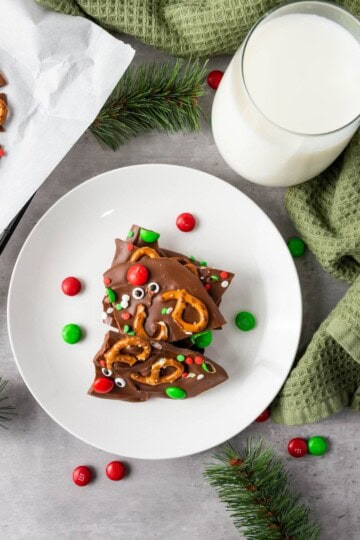 Served chocolate bark on a plate with a glass of milk and cloth underneath.