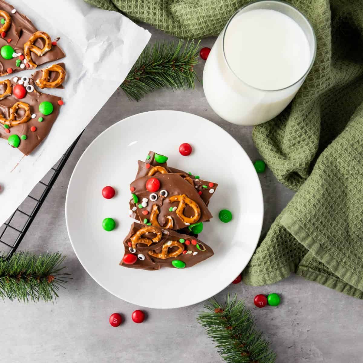 Served chocolate bark on a plate with a glass of milk and cloth underneath.