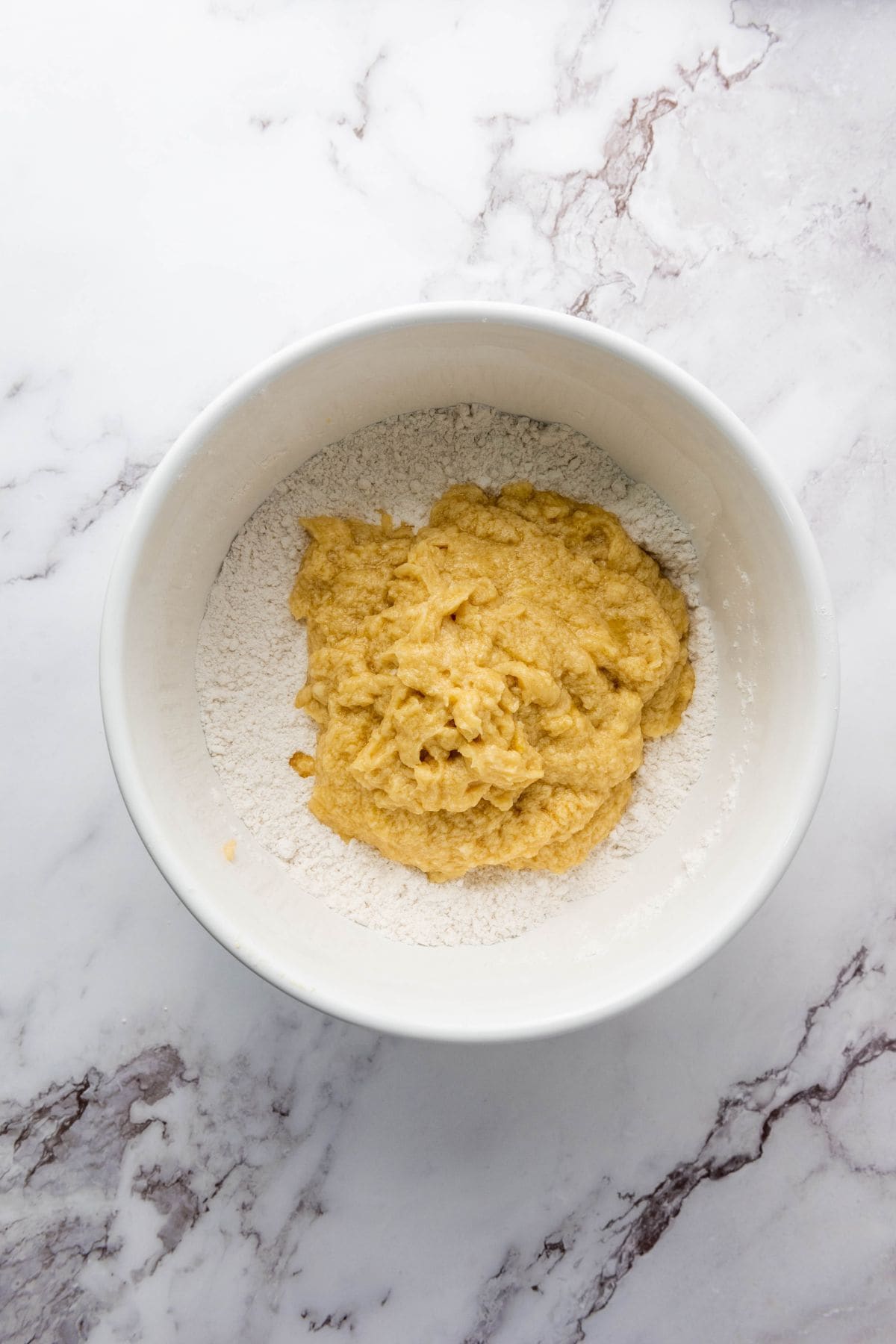 A bowl containing cookie mixture for Christmas M&M cookies.