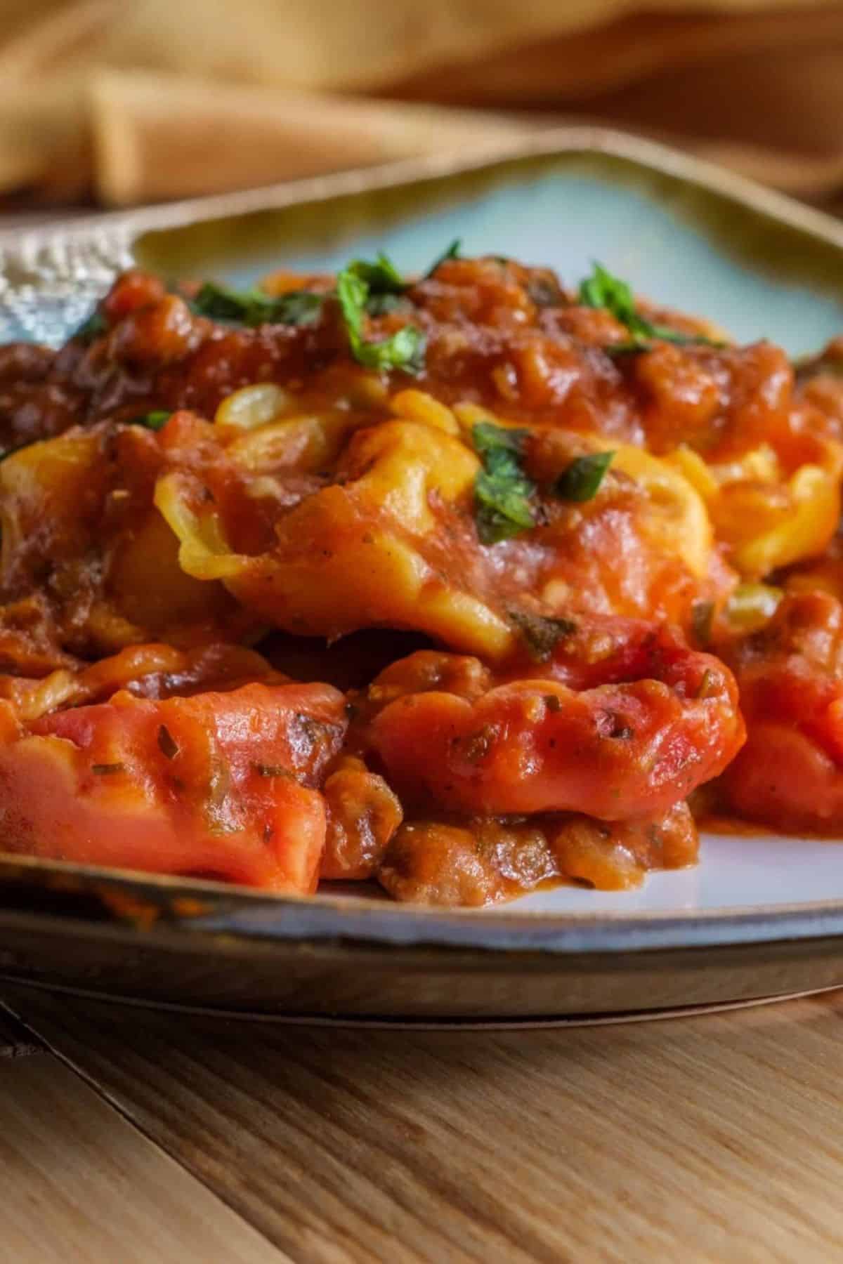 Close-up of cheesy baked tortellini served on a plate, showing the melted cheese and pasta details.