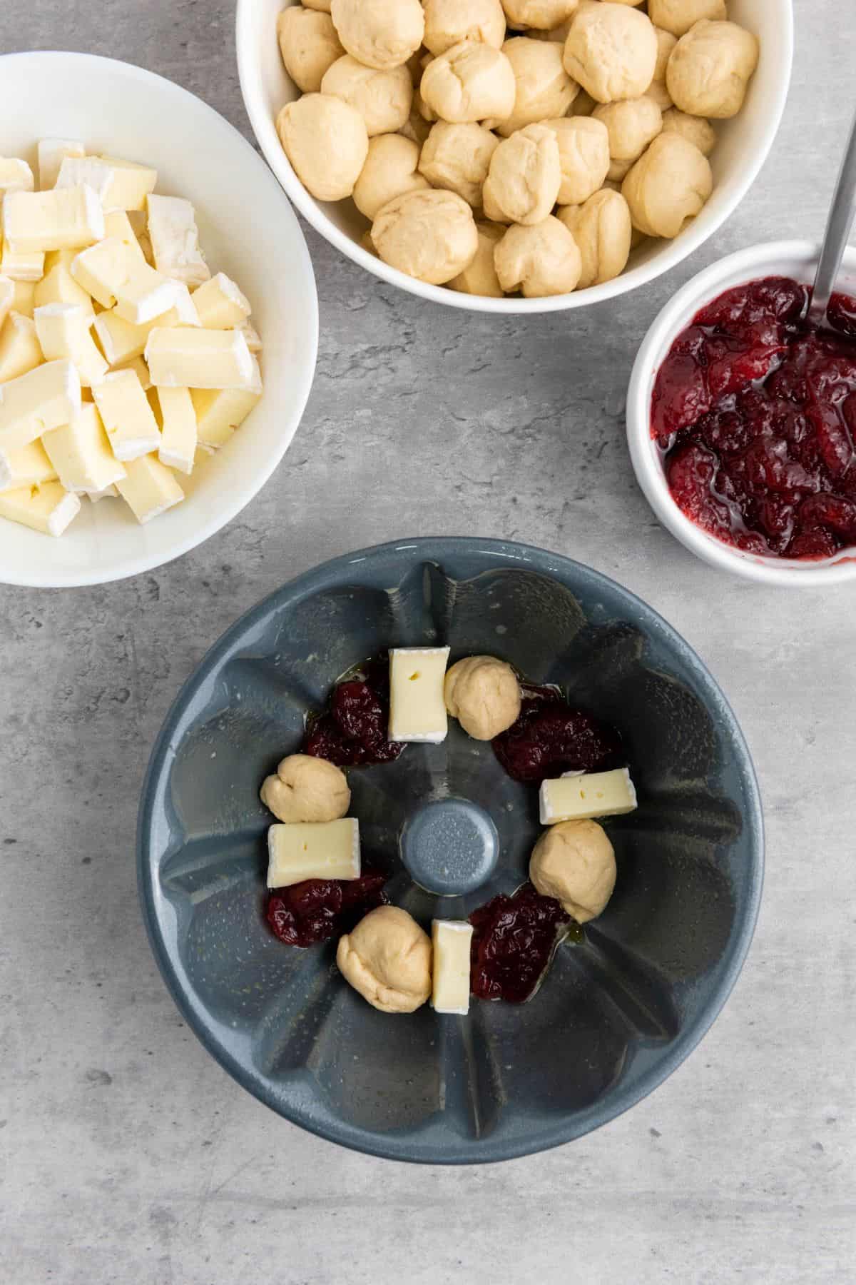 A mixing bowl filled with ingredients before cooking surrounded with other ingredients.