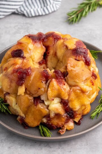 Mini pull-apart bread served on a plate with a cloth beside it.
