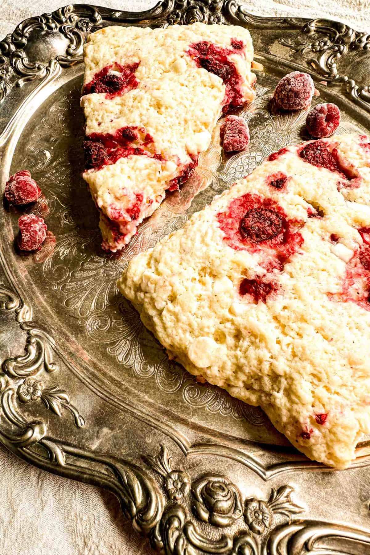 Close-up of Christmas Sourdough Scones with visible raspberries, served on a decorative tray, showing their golden edges and fluffy texture.
