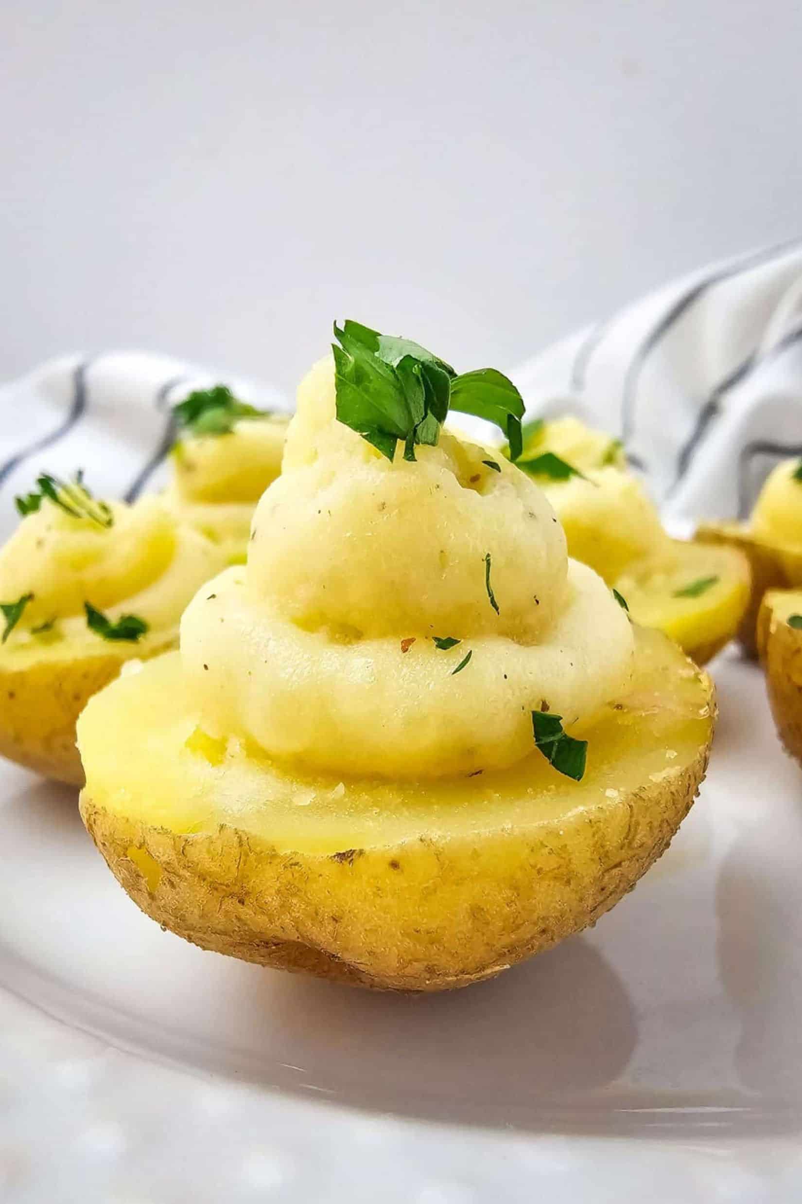 Close-up of deviled eggs garnished with green herbs on a plate.