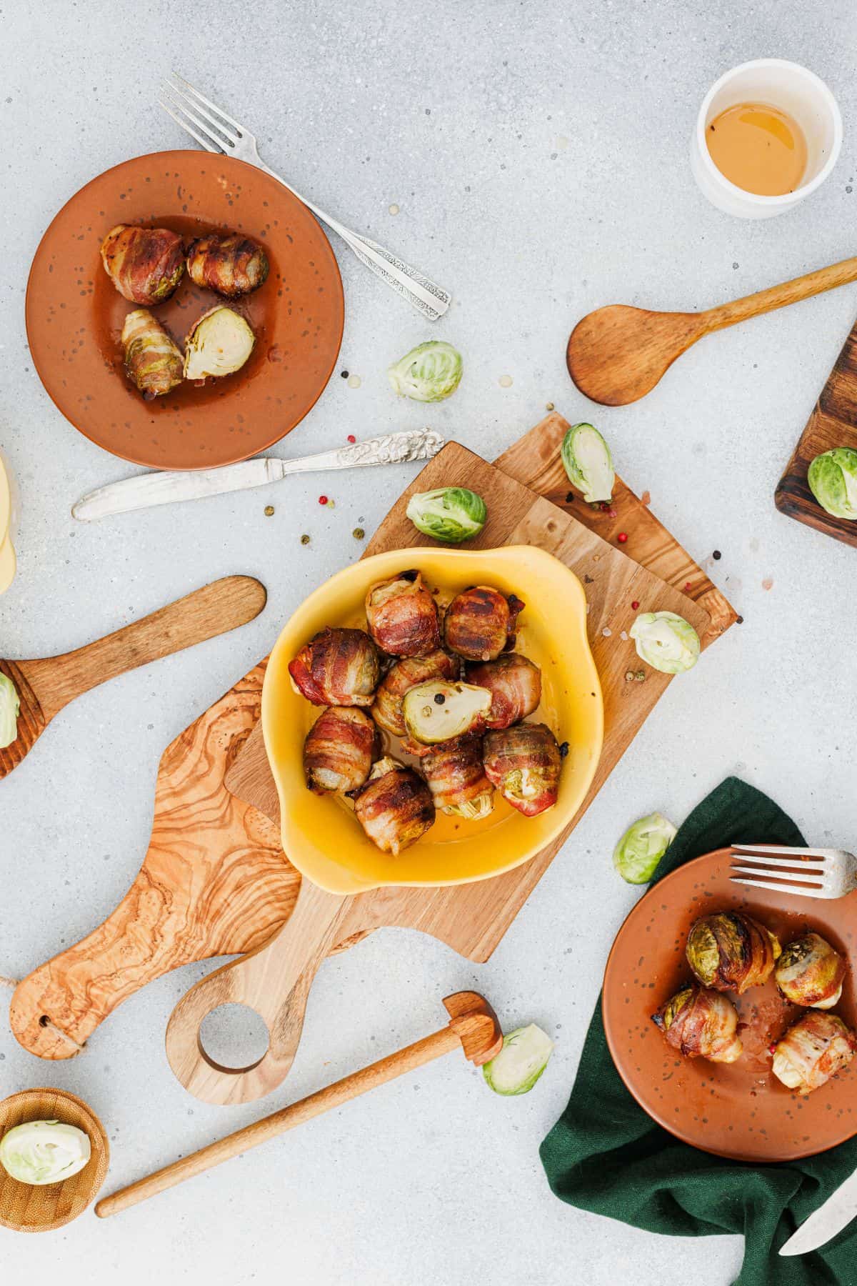 Maple glazed bacon arranged in a serving dish, surrounded by additional pieces of crispy bacon.
