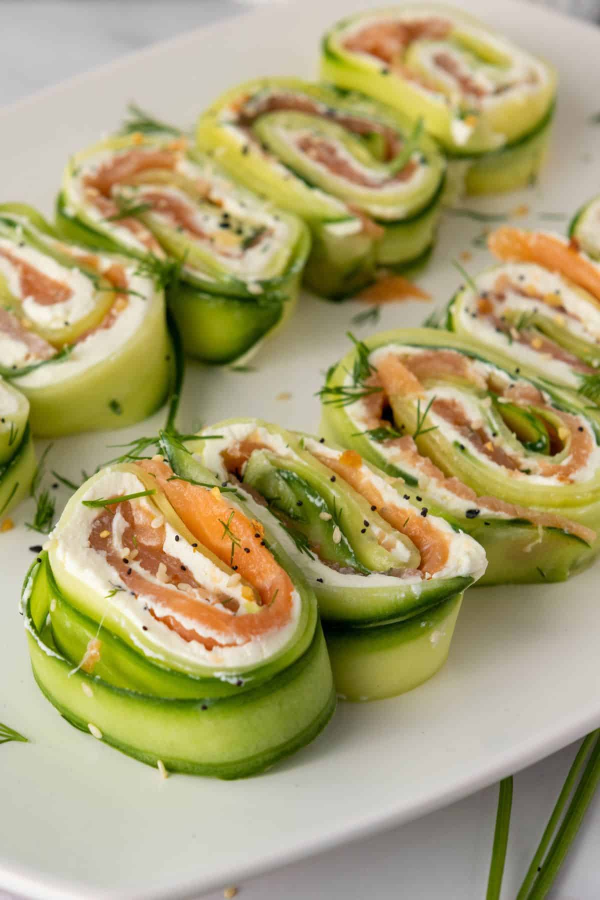 Close-up of everything bagel cucumber rolls filled with smoked salmon and cream cheese, sprinkled with everything bagel seasoning.