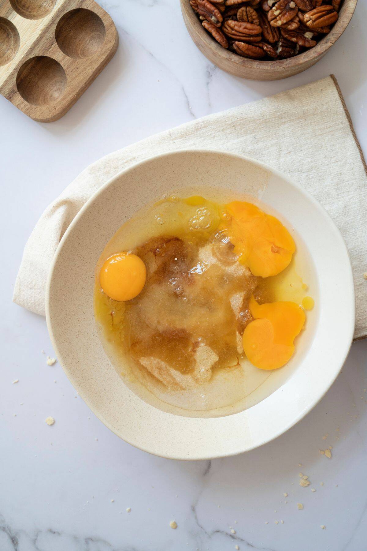 A medium bowl with a smooth pie mixture, showing whole eggs clearly visible in the batter.