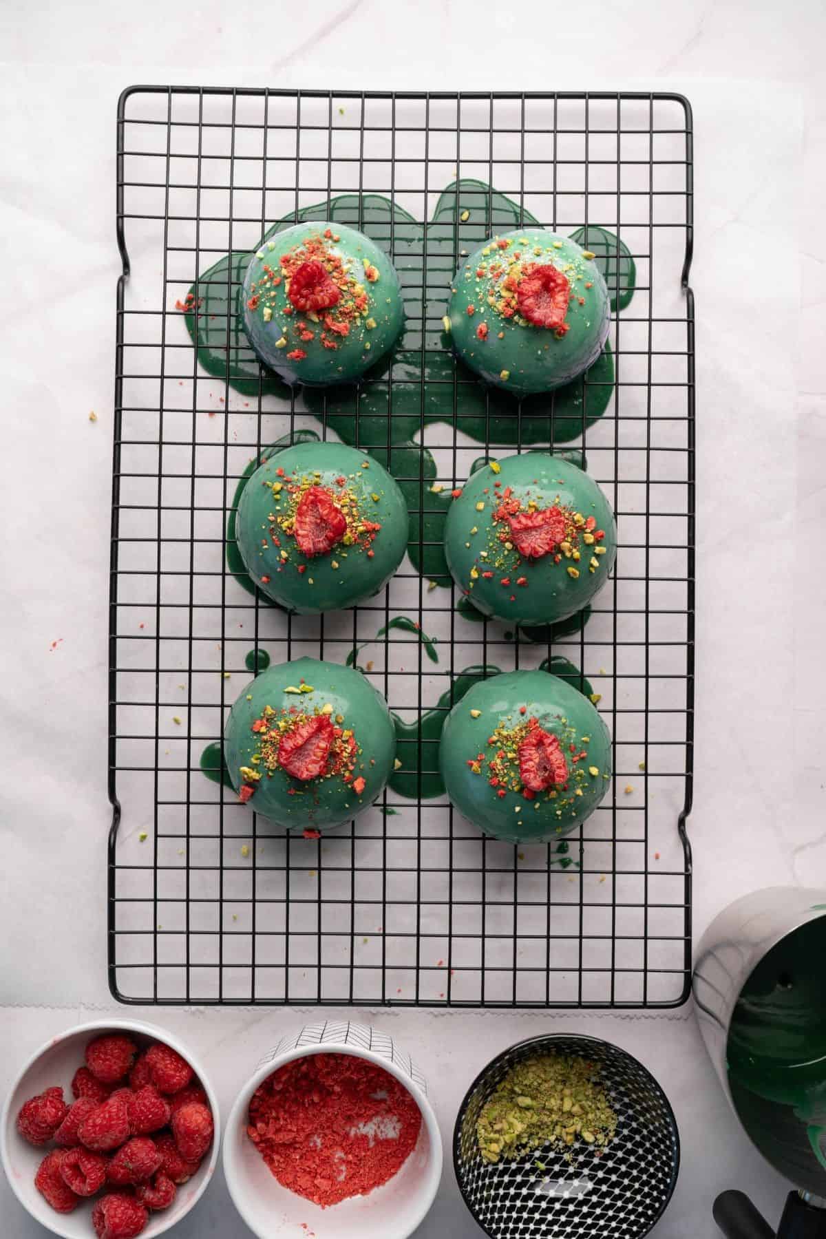 A dome-shaped dessert on a plate, surrounded with small bowls of ingredients used for making it.