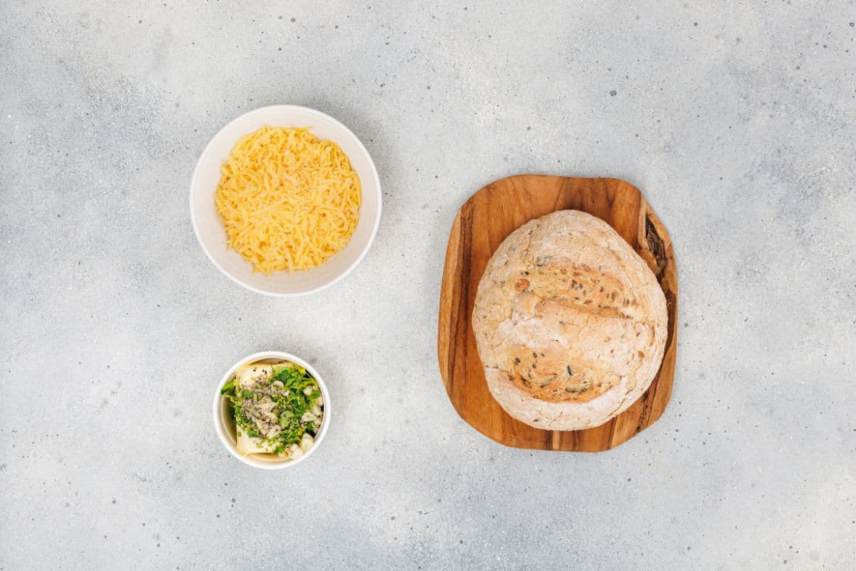 Ingredients for cheesy pull-apart garlic bread neatly arranged on a surface.