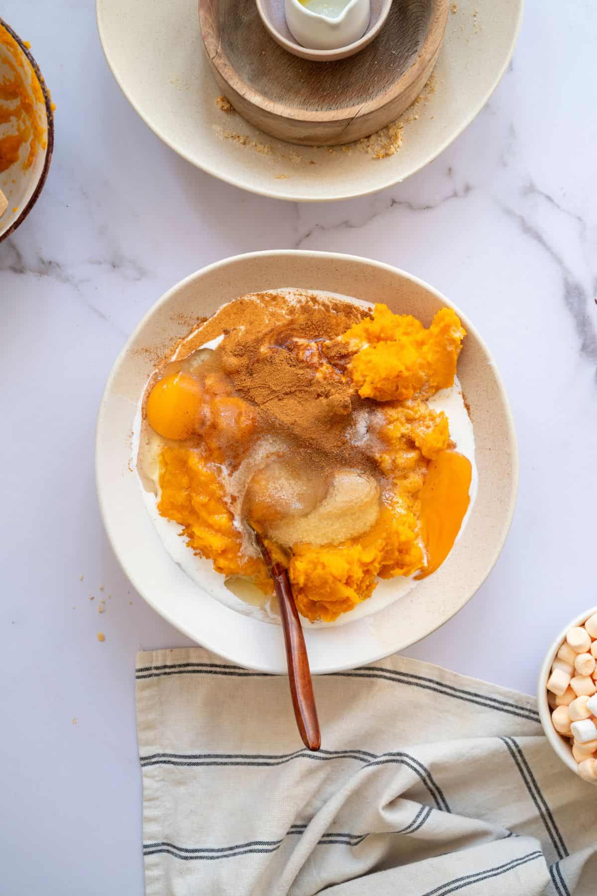 Ingredients being mixed in a medium bowl with a spoon resting inside.