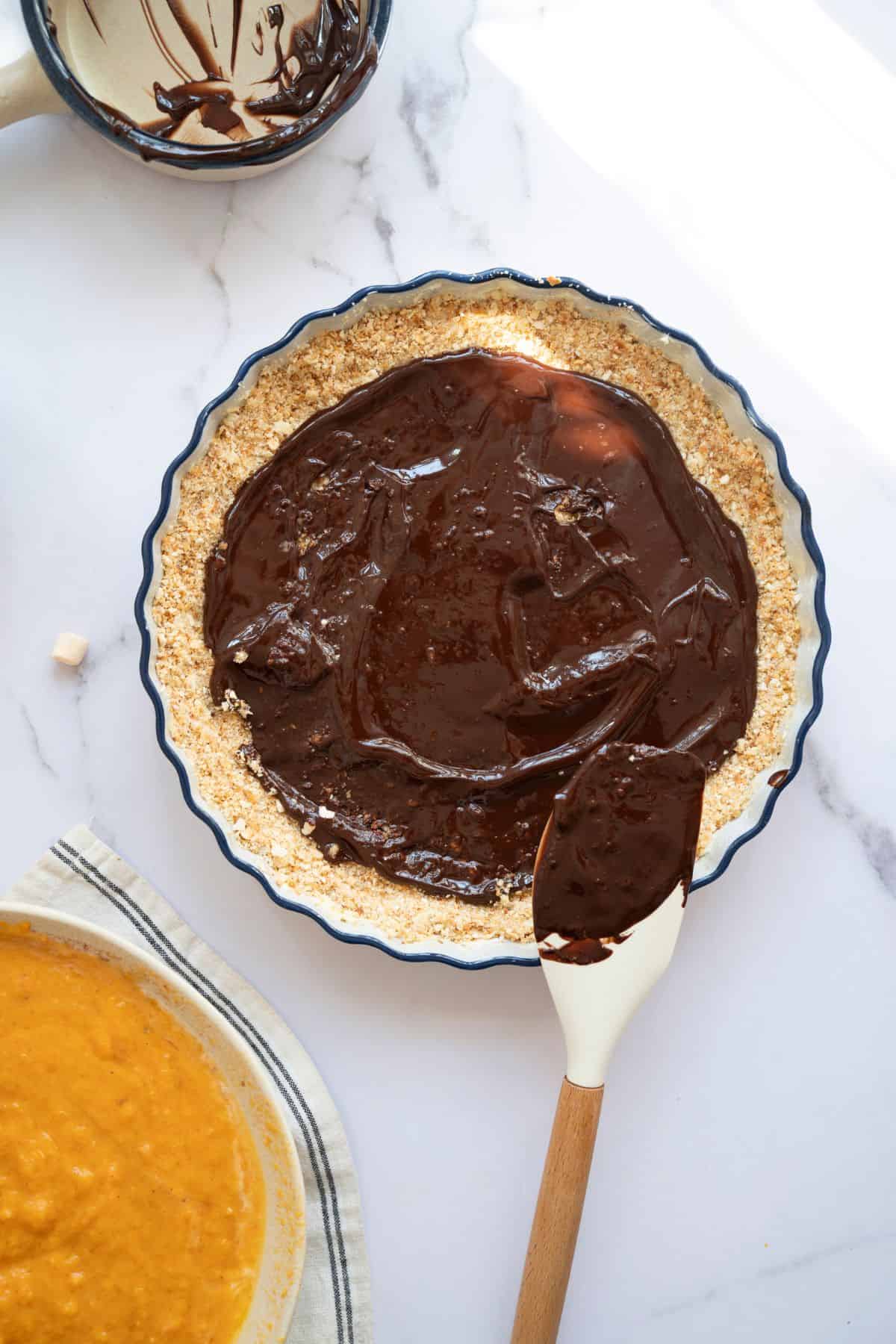 Melted dark chocolate evenly spread over the pie crust.