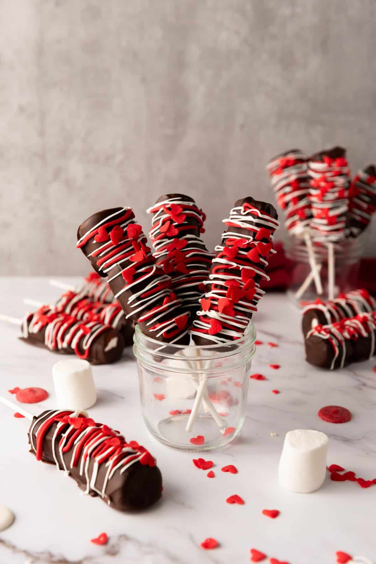 Delicious chocolate cake pops decorated with red and white icing, perfect for Valentine's Day or special occasions.