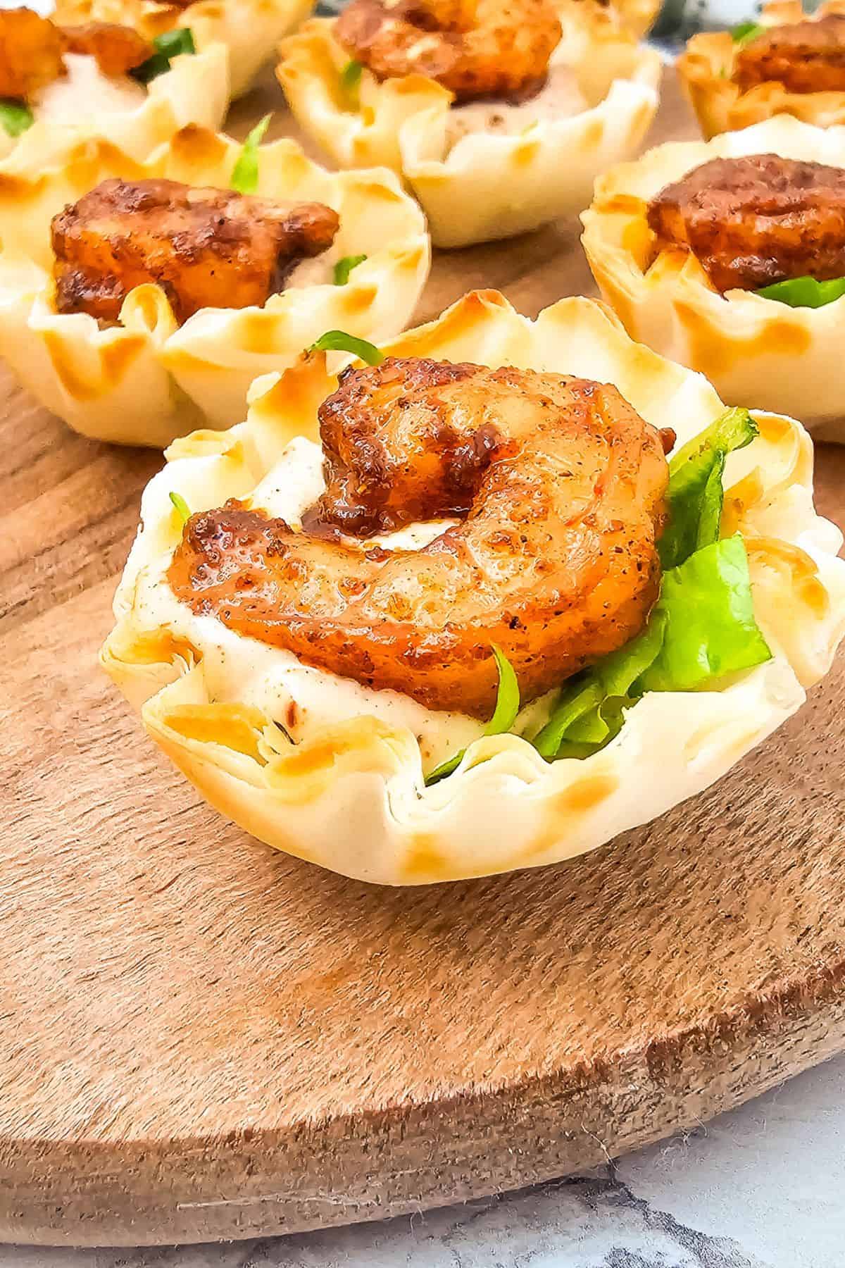 Delicious shrimp cups with creamy filling, crispy shells, and fresh greens, perfect for appetizers or snacks.