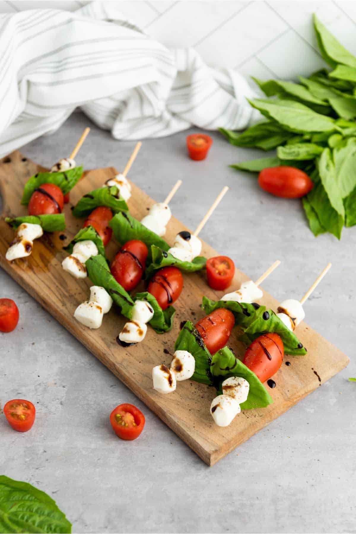 Delicious homemade Caprese skewers with cherry tomatoes, mozzarella, basil, drizzled with balsamic glaze. Perfect appetizer!.