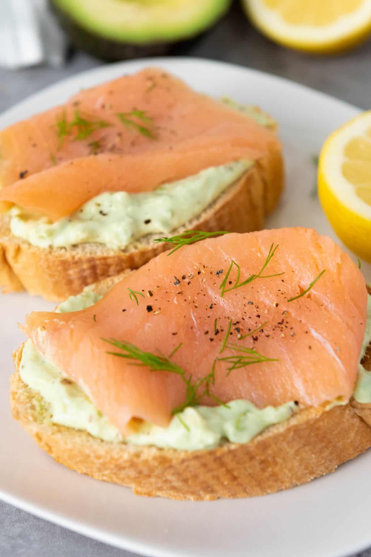 Fresh smoked salmon atop a bagel with cream cheese, garnished with herbs and black pepper. Perfect breakfast or brunch choice.