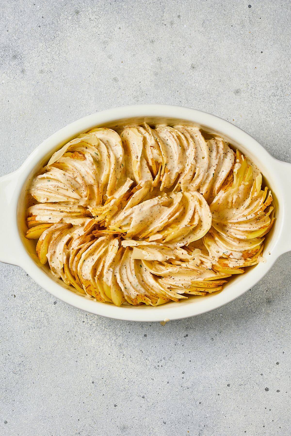 Comfort food featuring layered potatoes and seasoned chicken in a baking dish.