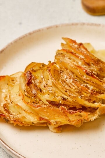 Closer view of scalloped potatoes in a plate, showing the golden top and creamy layers.